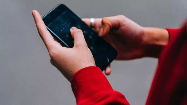 Person holding phone with two hands, using both thumbs to scroll.