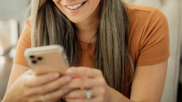 Person holding phone with two hands, scrolling with one thumb.