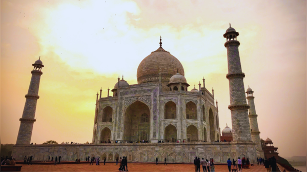 The Taj Mahal, a pristine white marble mausoleum, reflecting in the surrounding pools.