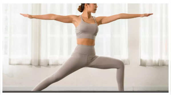 Woman practicing Warrior Pose for strength and metabolism boost