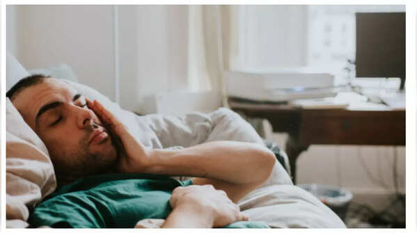 Exhausted person resting head on hands.